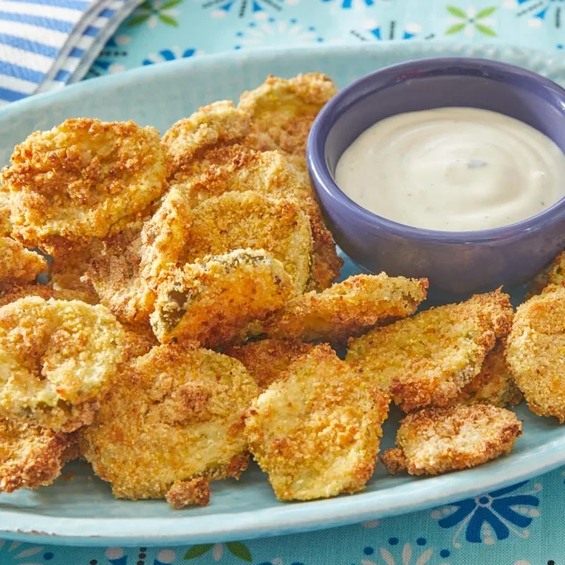 pioneer woman air fryer pickles served golden and crispy on a plate with ranch dressing