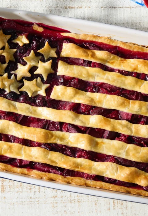 pioneer woman american flag pie with raspberry plum and blueberry fillings decorated with dough stars and stripes in a baking dish