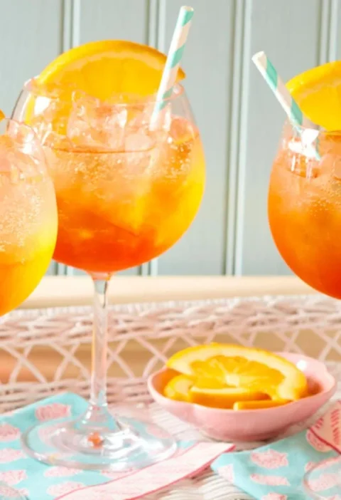 Pioneer Woman Aperol Spritz cocktail in a wine glass filled with ice, showing the bright orange drink topped with an orange slice