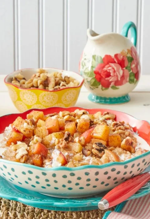 A bowl of apple cinnamon oatmeal topped with caramelized honeycrisp apples, brown sugar and walnuts