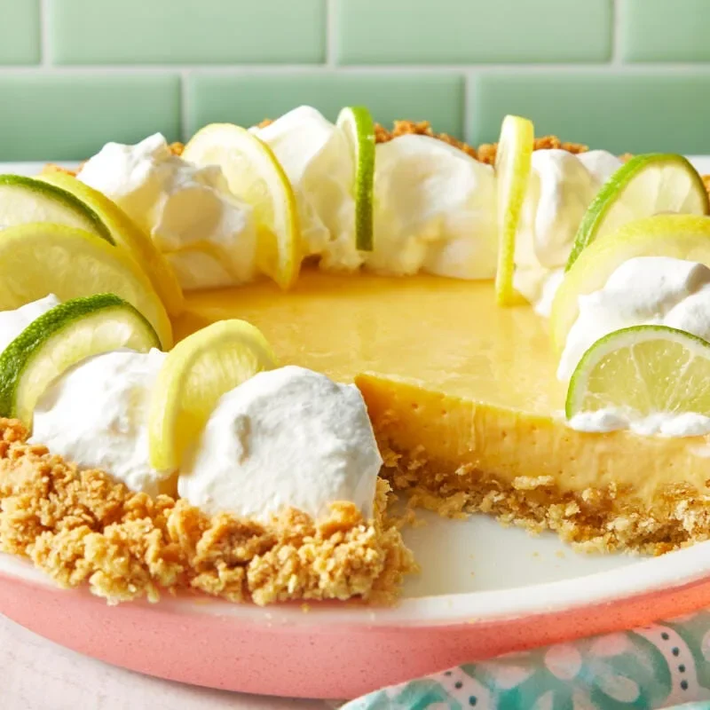 Pioneer Woman Atlantic Beach Pie with whipped cream topping and lemon and lime slices on a golden saltine cracker crust