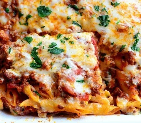 Baked ziti in a casserole dish with melted mozzarella and parsley, a pioneer woman baked ziti recipe