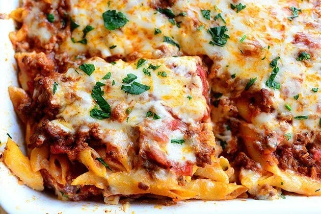 Baked ziti in a casserole dish with melted mozzarella and parsley, a pioneer woman baked ziti recipe