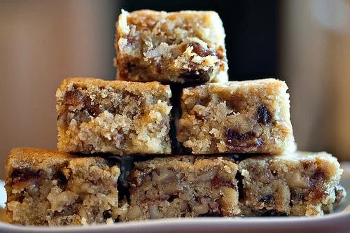 A pan of pioneer woman bar loaded with chopped dates, walnuts and pecans in a rich buttery batter