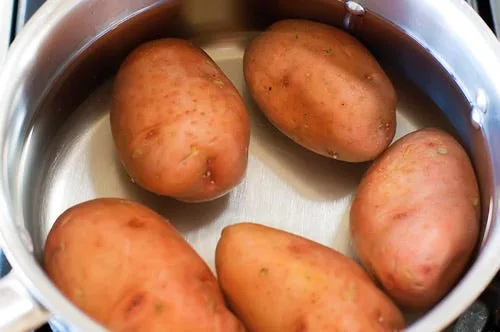 Basic breakfast potatoes with crispy golden edges and diced onions in a cast iron skillet