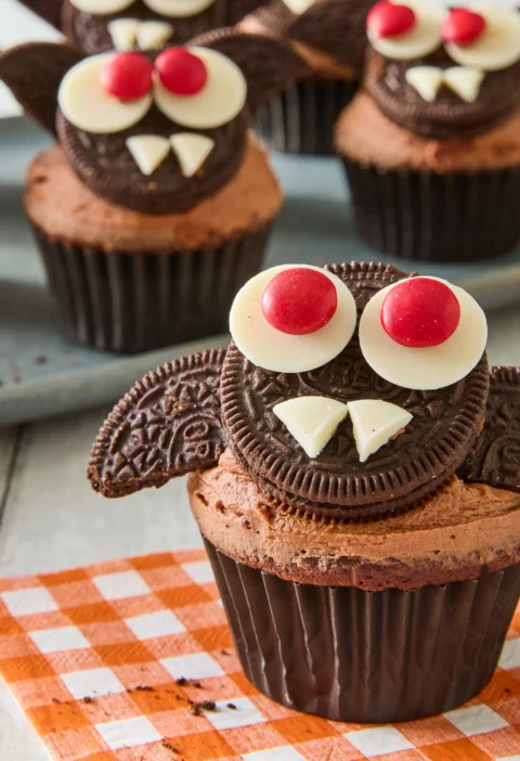 Pioneer Woman bat cupcakes with chocolate frosting, Oreo cookie wings, and candy melt eyes arranged on a platter