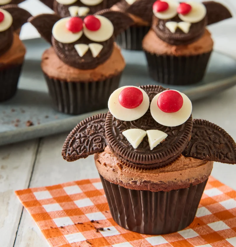 Pioneer Woman bat cupcakes with chocolate frosting, Oreo cookie wings, and candy melt eyes arranged on a platter