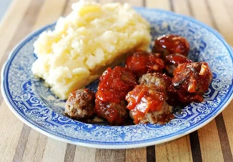 BBQ meatballs in a tangy ketchup sauce in a baking dish, a classic Pioneer Woman comfort food recipe